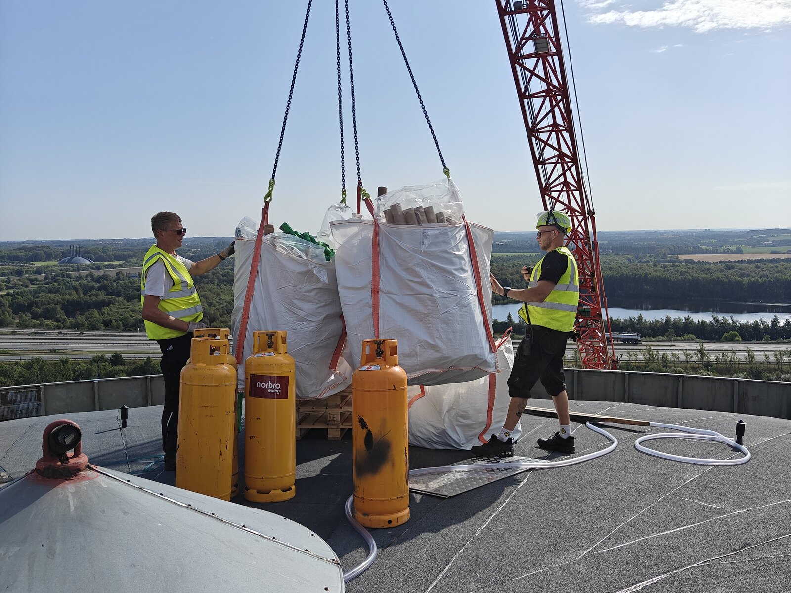 Kranen hejser ballast og gasflasker op på taget