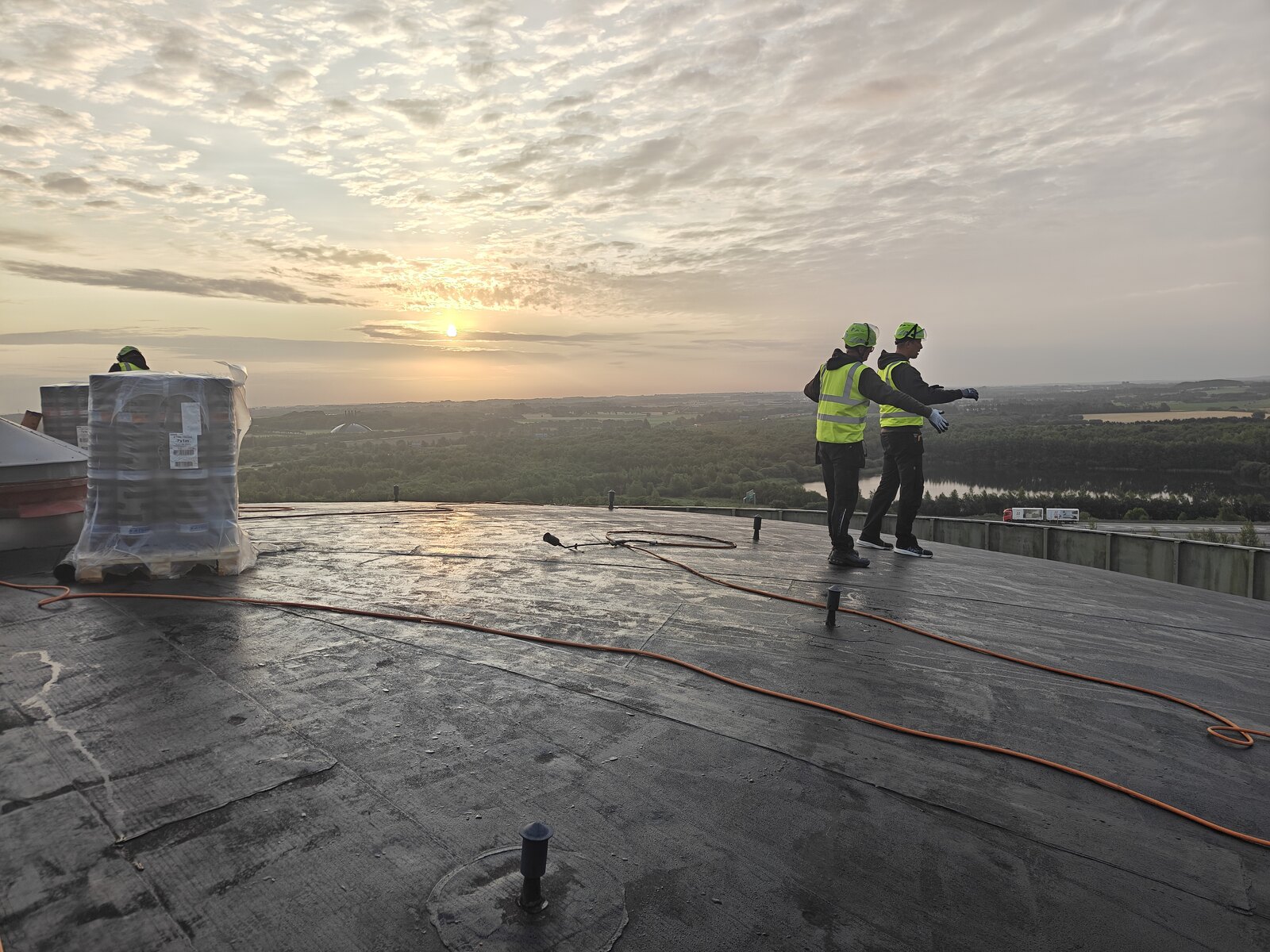 Arbejde på siloens tag i solnedgang